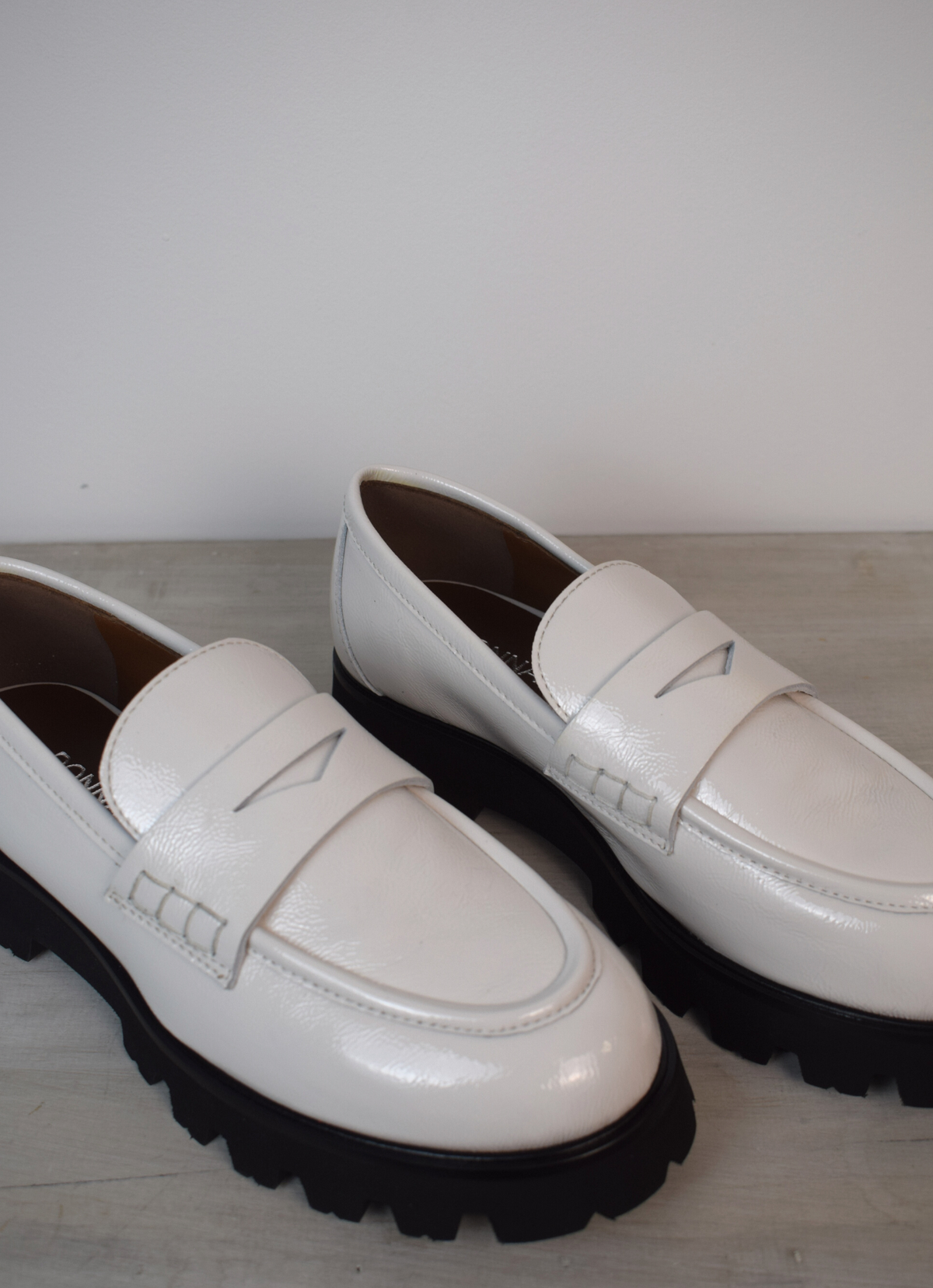 White loafers with black flat-form sole 