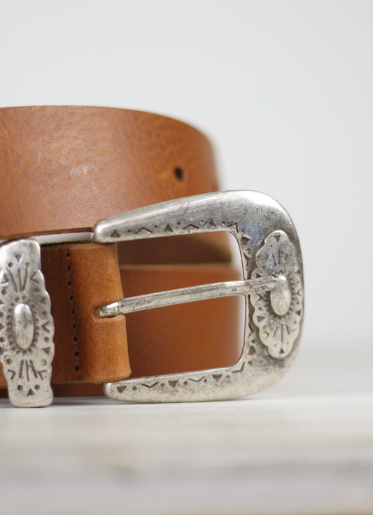 Western inspired leather belt from Spanish brand Mercules. The Fender Belt is cut from a soft brown leather and has a silver coloured buckle and pointer.  A perfect style and width for jeans, this belt can also be styled over dresses and knitwear too.