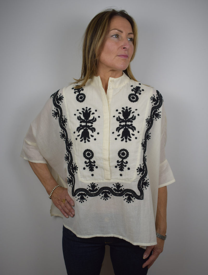 Cream poncho style blouse with bold black embroidery and stand up collar