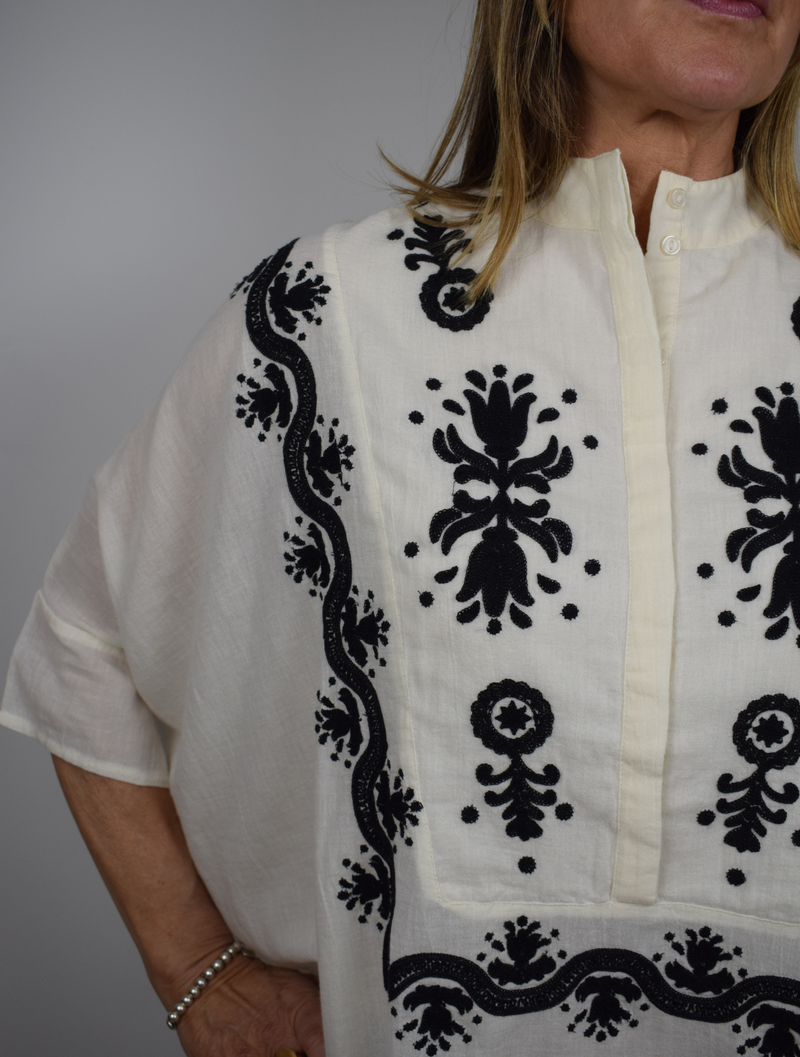 Cream poncho style blouse with bold black embroidery and stand up collar