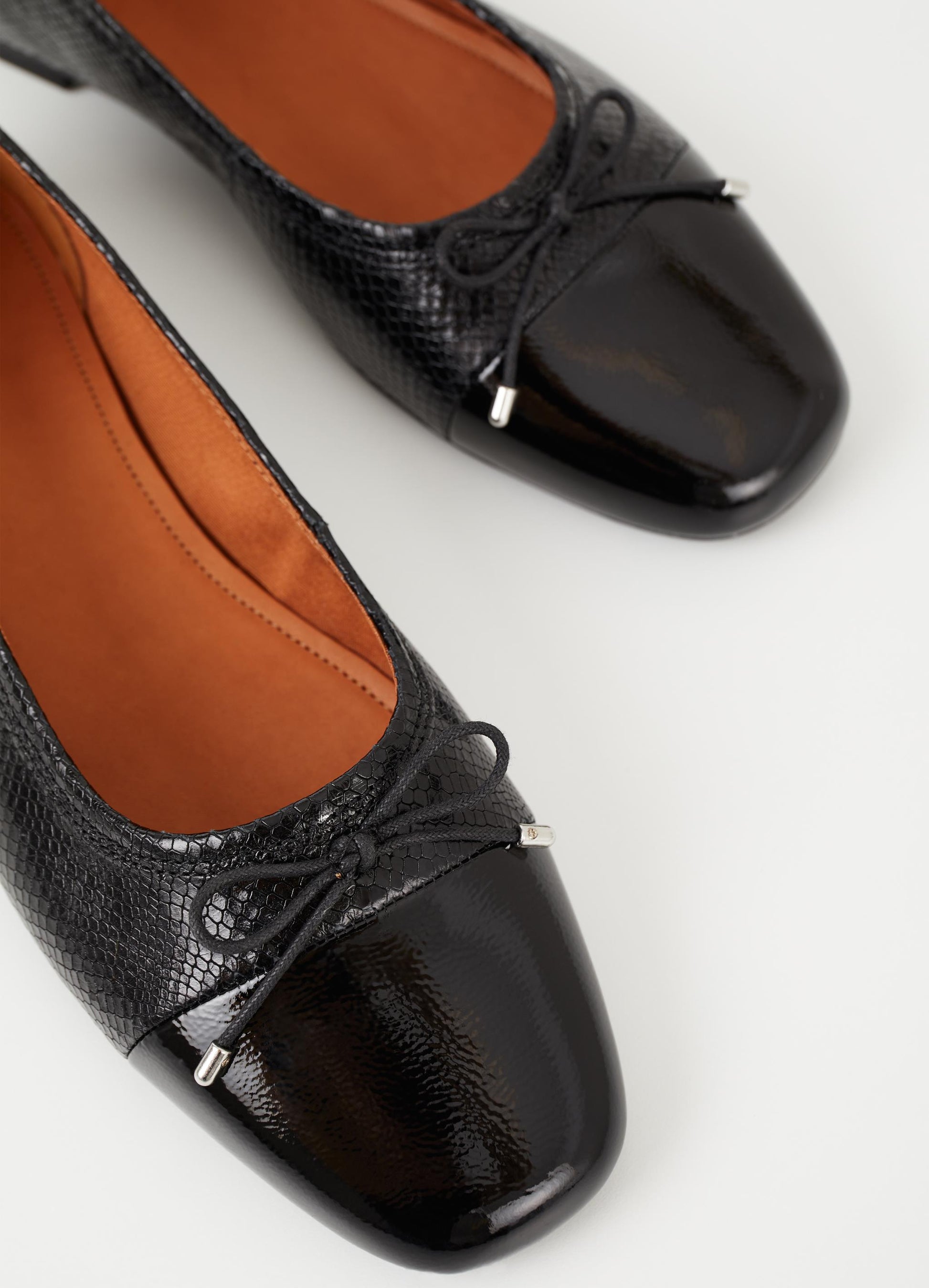 Black leather ballet pump with croc effect leather a patent toe and tie details with silver tips