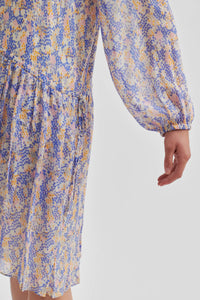 Ditsy floral knee length dress with dropped waistline long sleeves and half button through placket with an ecru base and blue, purple and yellow florals