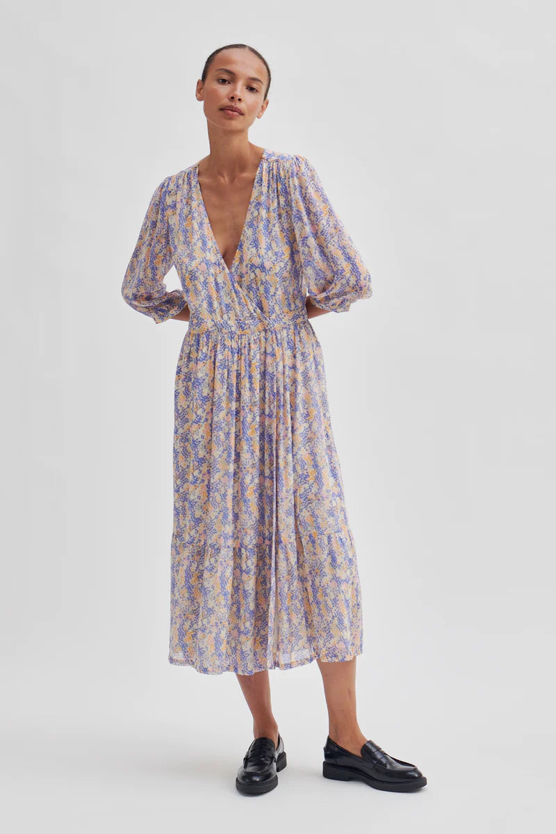 Wrap dress with V neck and three quarter length sleeves on an ecru base with blue, lilac and yellow ditsy floral print midi in length