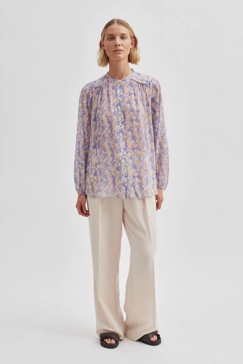 Semi sheer ecru top with ditsy blue orange and lavender floral print with full length placket long sleeves and single button fastening