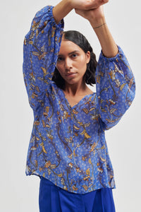 Cornflower blue pull on semi sheer top with long sleeves and elasticated cuffs v neck and flat piping detail