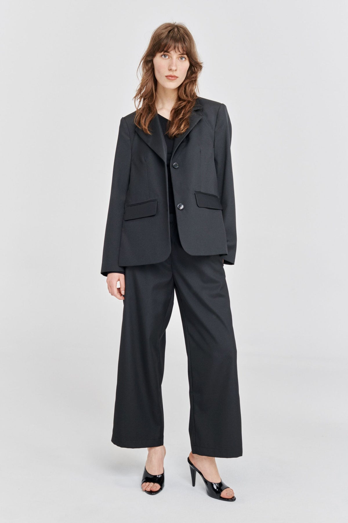 Classic black blazer with single breasted plastic button fastenings fabric tie belt and long side vents