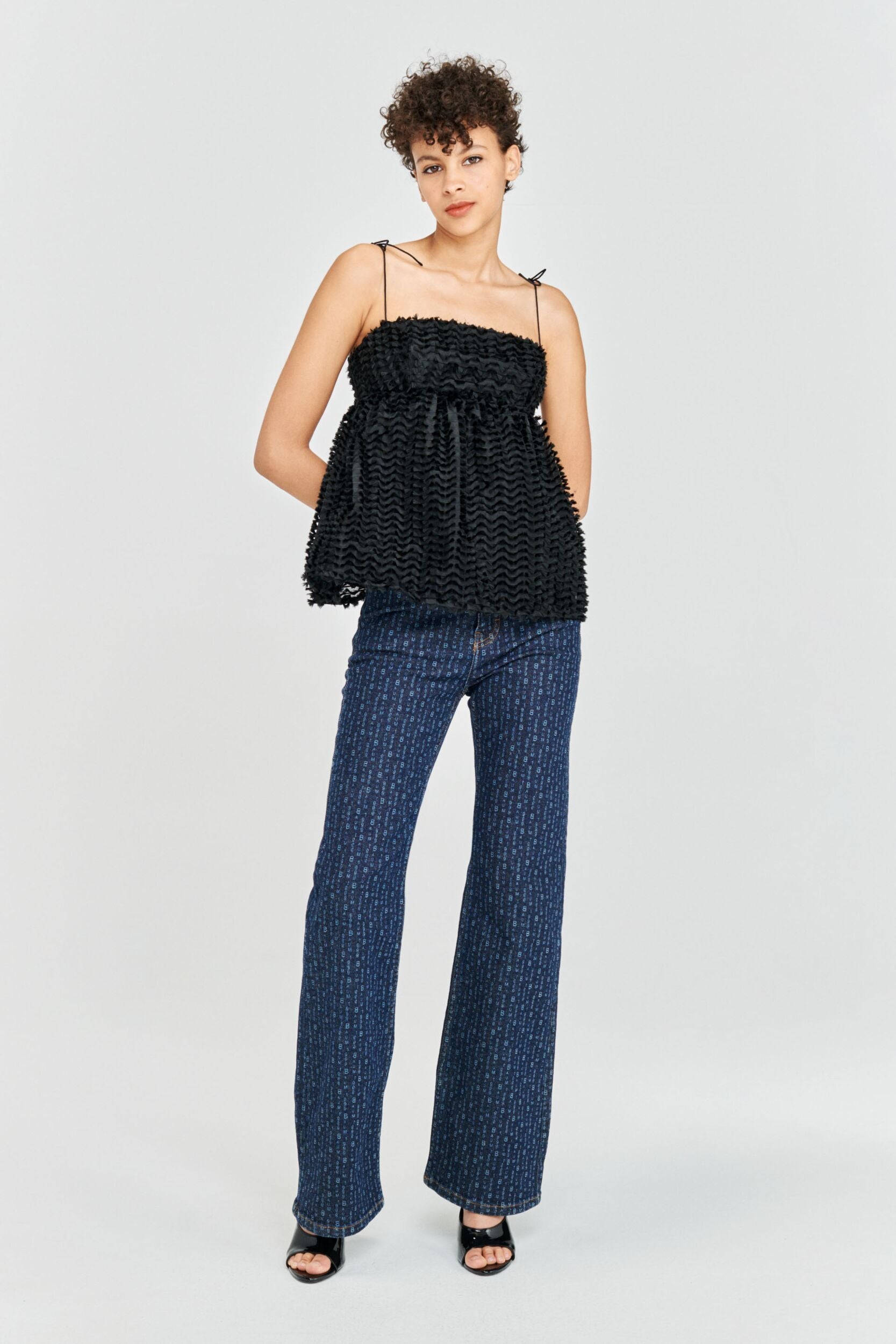 Strappy black top with spaghetti straps and tiny tassel details on fabric