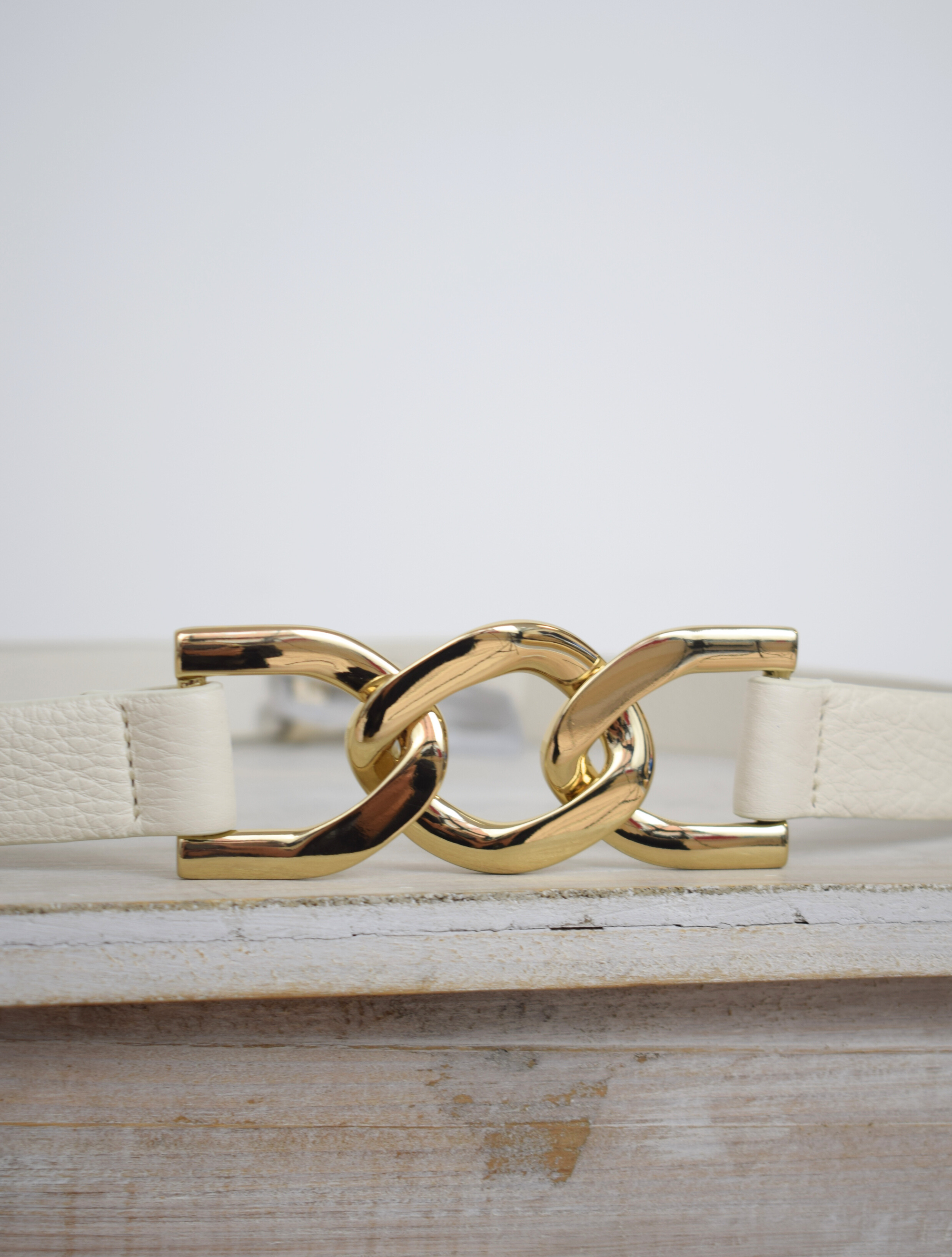 Ivory leather belt with gold metallic link feature at the front and press stud fastening at the back