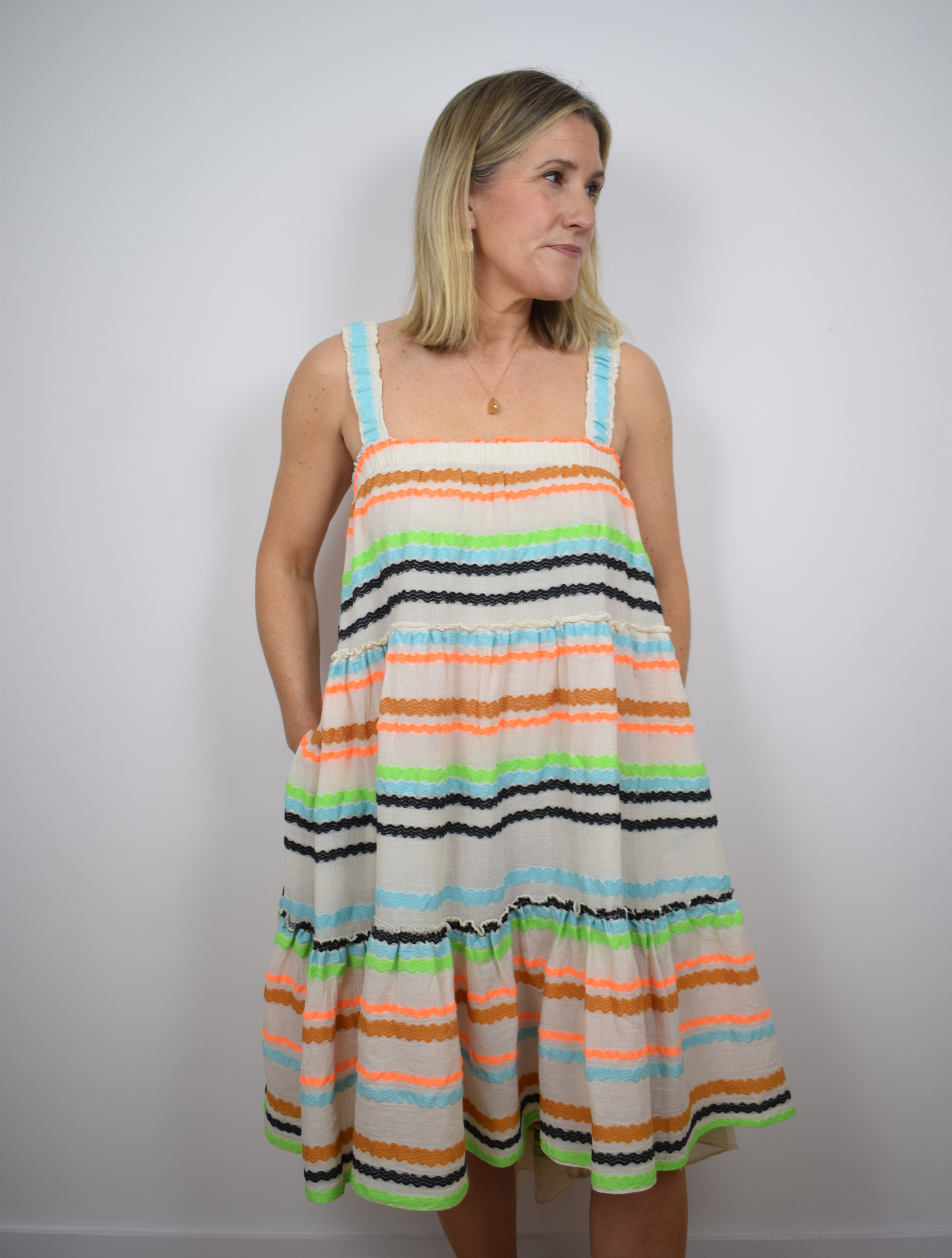 Ecru dress with blue, black, orange and brown frill stripes 