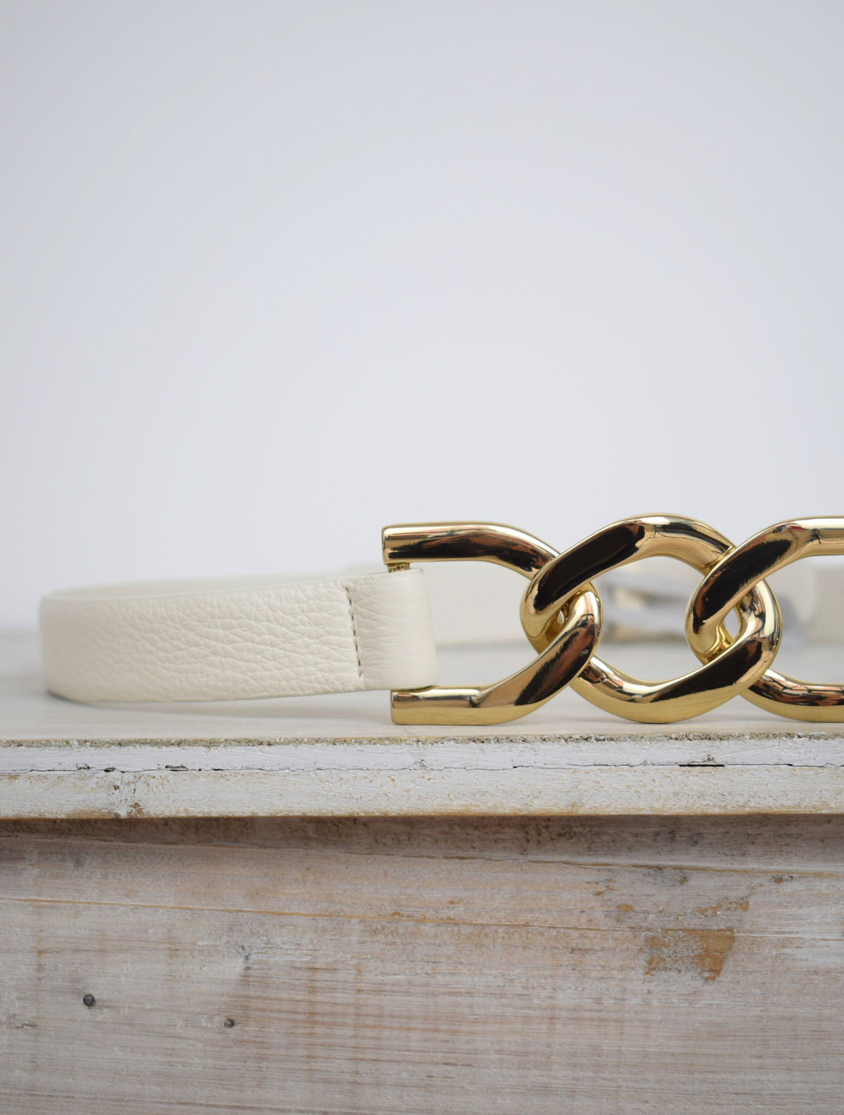 Ivory leather belt with gold metallic link feature at the front and press stud fastening at the back