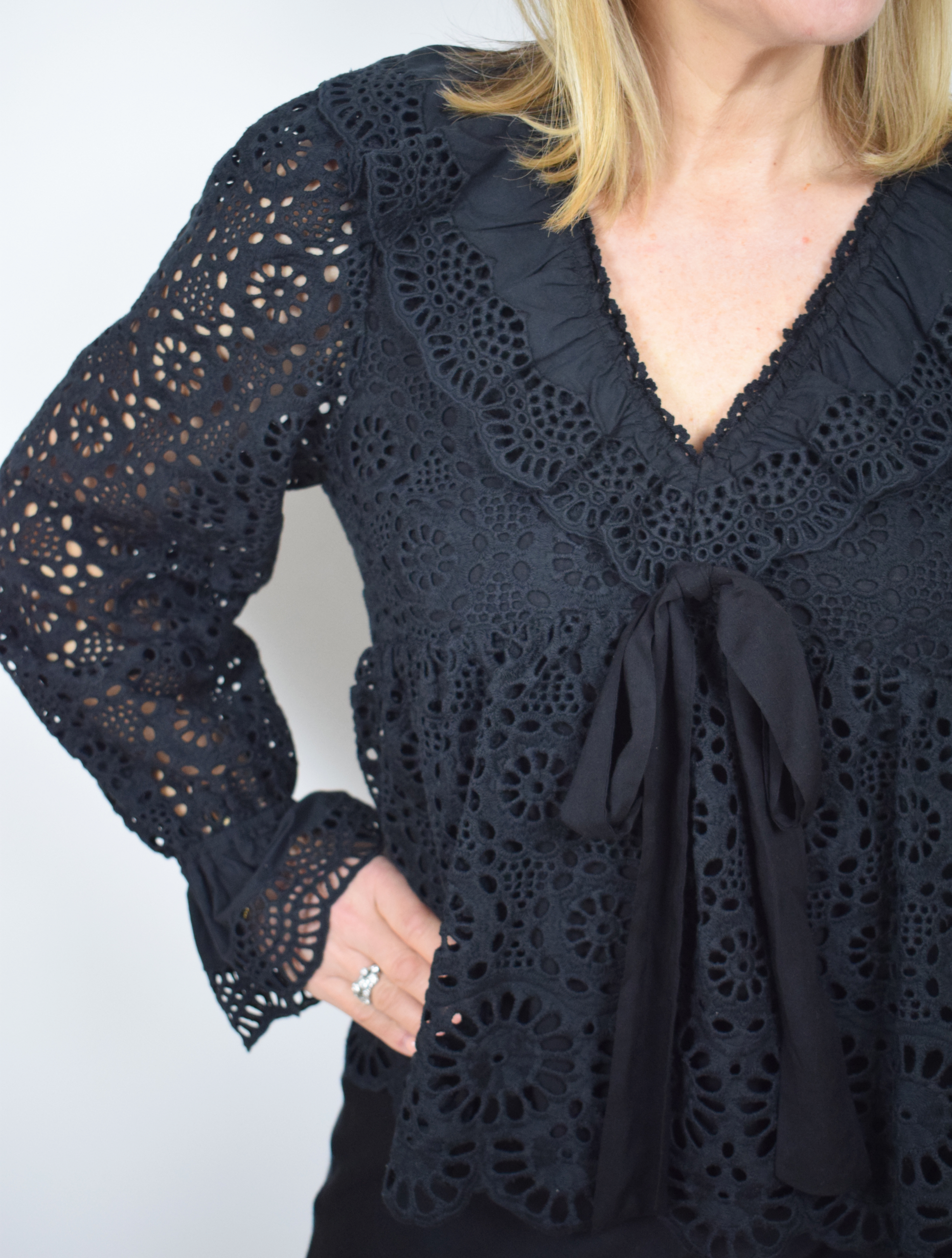 Black lace top with long sleeves and ruffle details with V neckline lined in the body