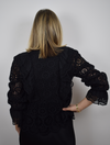 Black lace top with long sleeves and ruffle details with V neckline lined in the body