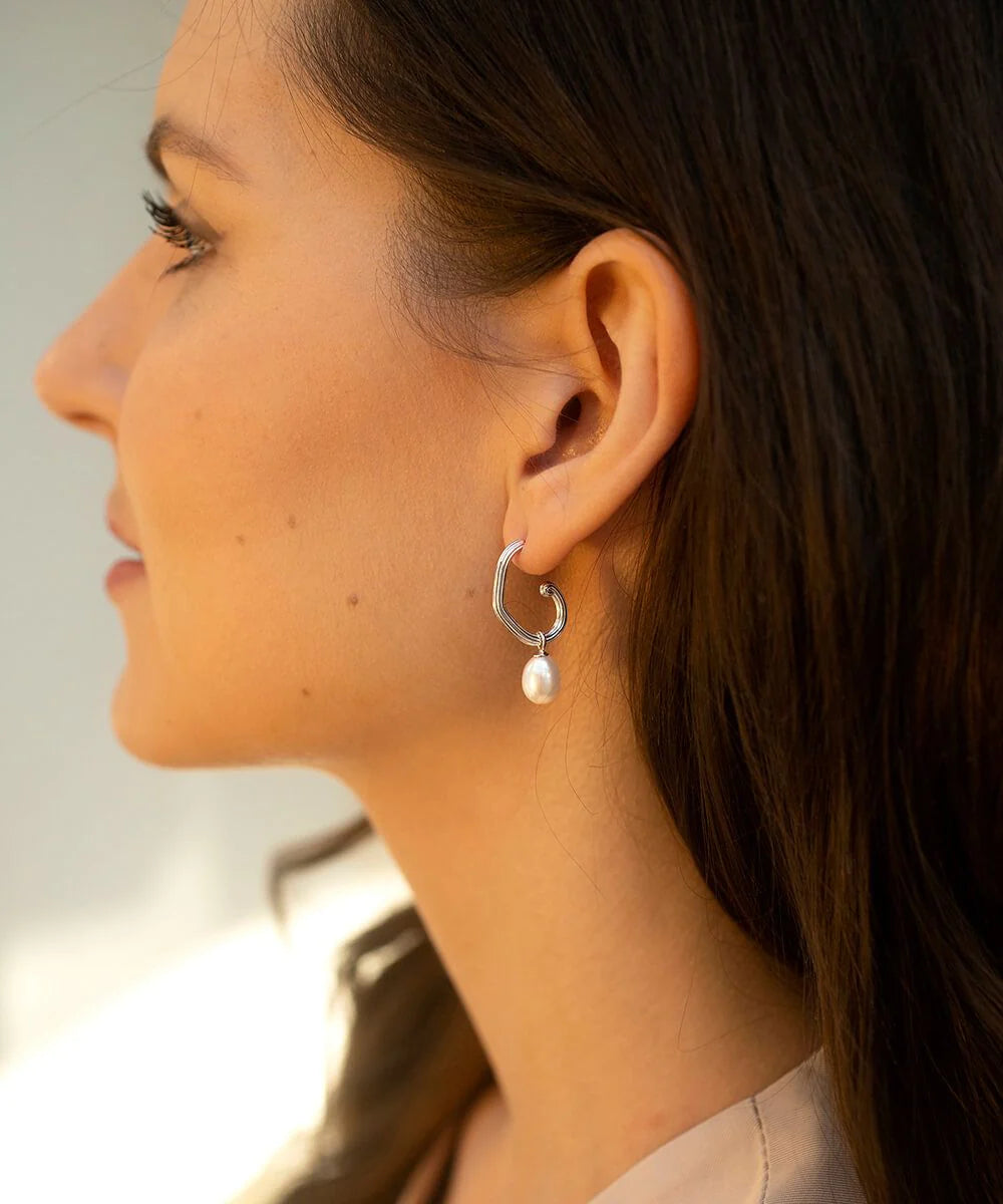 Silver grooved tubing hoop earrings with post and butterfly fastening and single pearl drop pendant