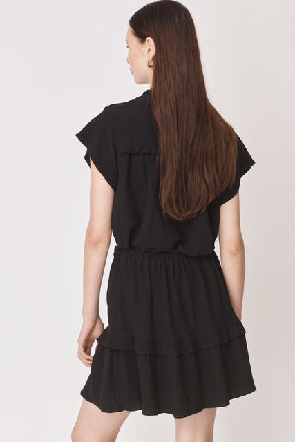Short sleeved black top with notch neck and ruffle detail in a textured fabric