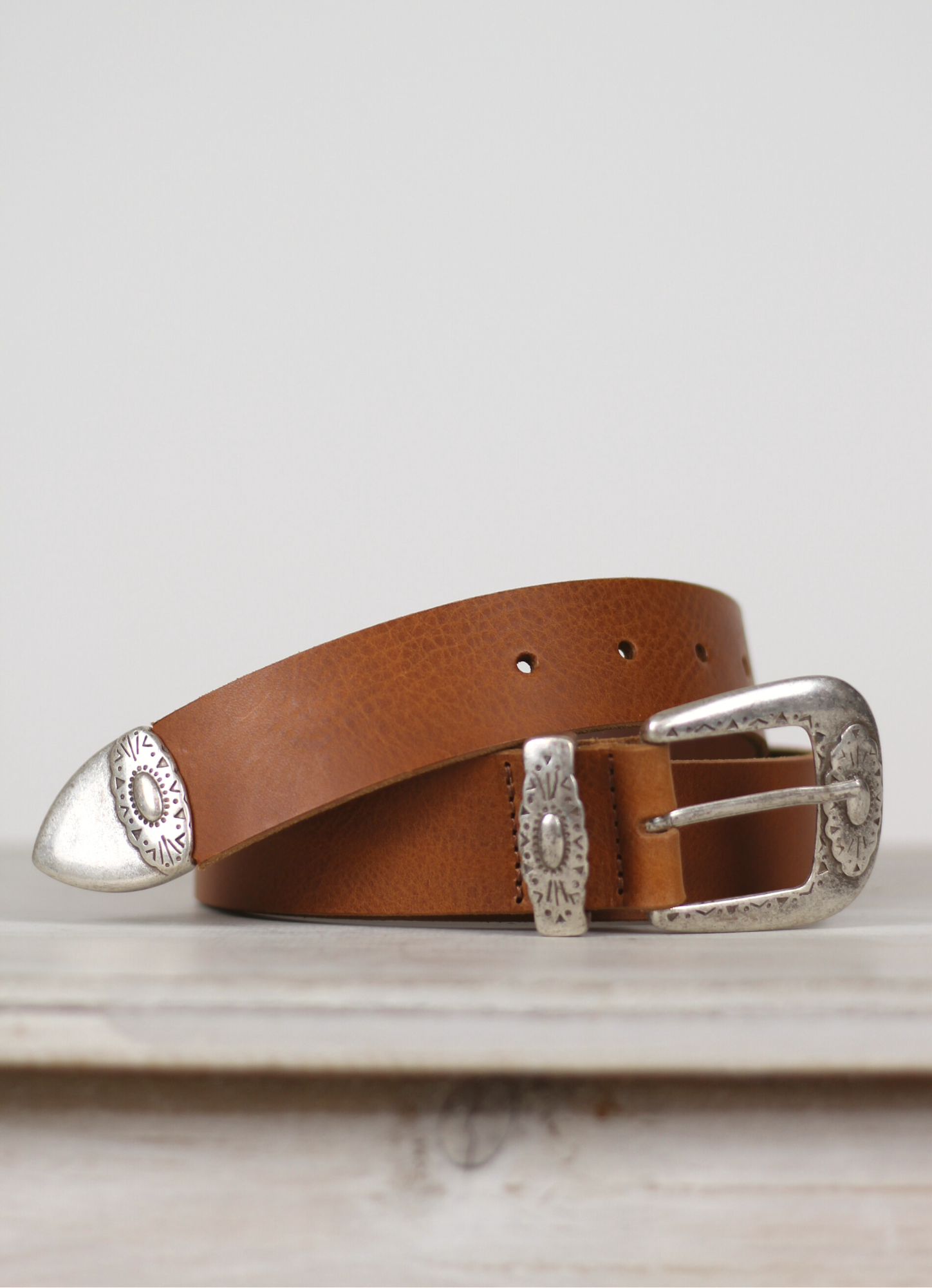 Western inspired leather belt from Spanish brand Mercules. The Fender Belt is cut from a soft brown leather and has a silver coloured buckle and pointer.  A perfect style and width for jeans, this belt can also be styled over dresses and knitwear too.
