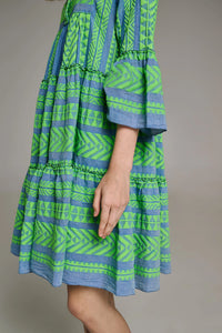 Denim blue base midi dress with panelled skirt and fluted bracelet length sleeves with green geometric all over embroidery