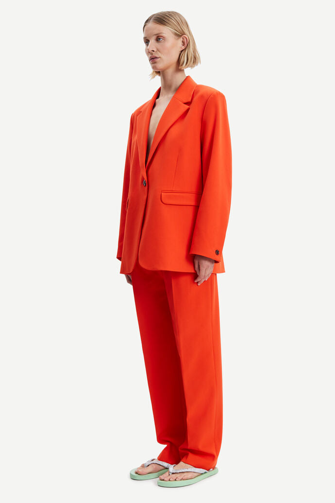 Orange single breasted blazer with single button fastening and long sleeves with two front flap pockets