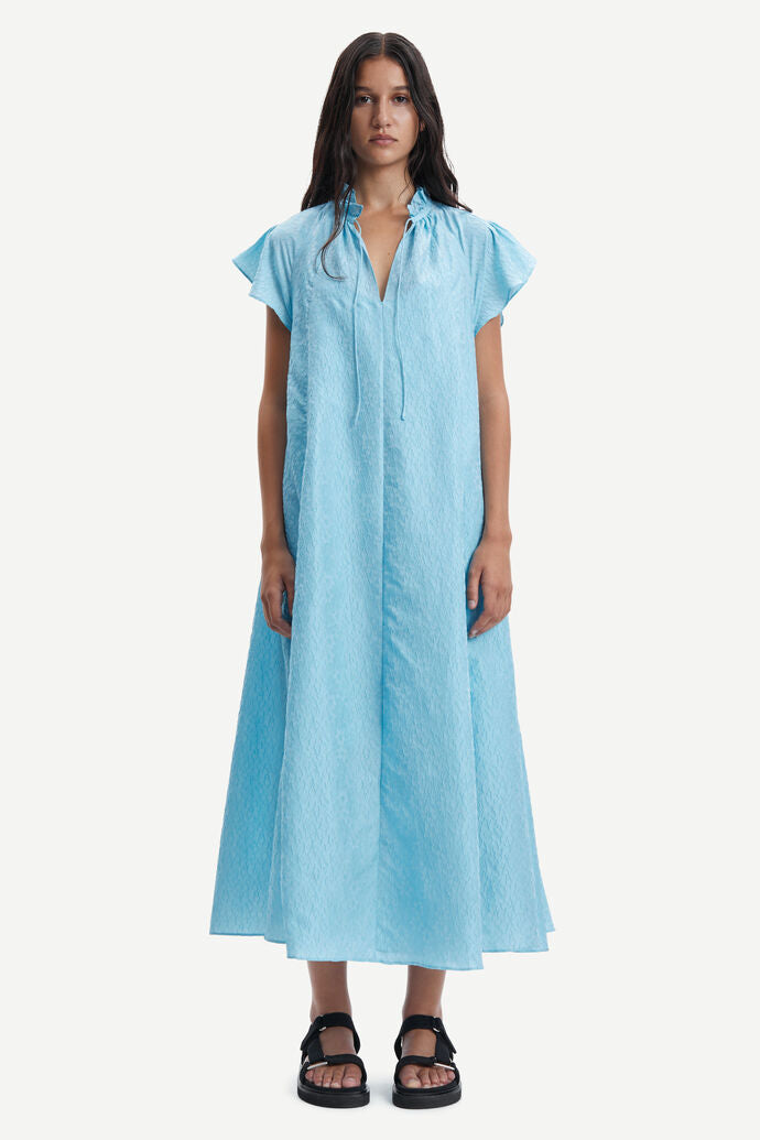 Long baby blue A line long dress with ruffle collar and capped sleeves made from a fabric embossed with small flowers