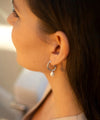 Silver grooved tubing hoop earrings with post and butterfly fastening and single pearl drop pendant