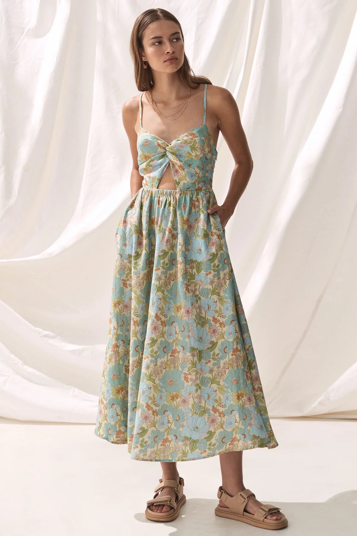 Blue green and floral midi dress with knotted front and peep hole detail and spaghetti straps that tie in a lace detail at the back
