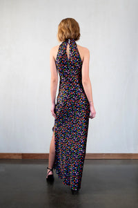 Black silk halterneck maxi dress with side split and vibrant ditsy floral print in vibrant colours