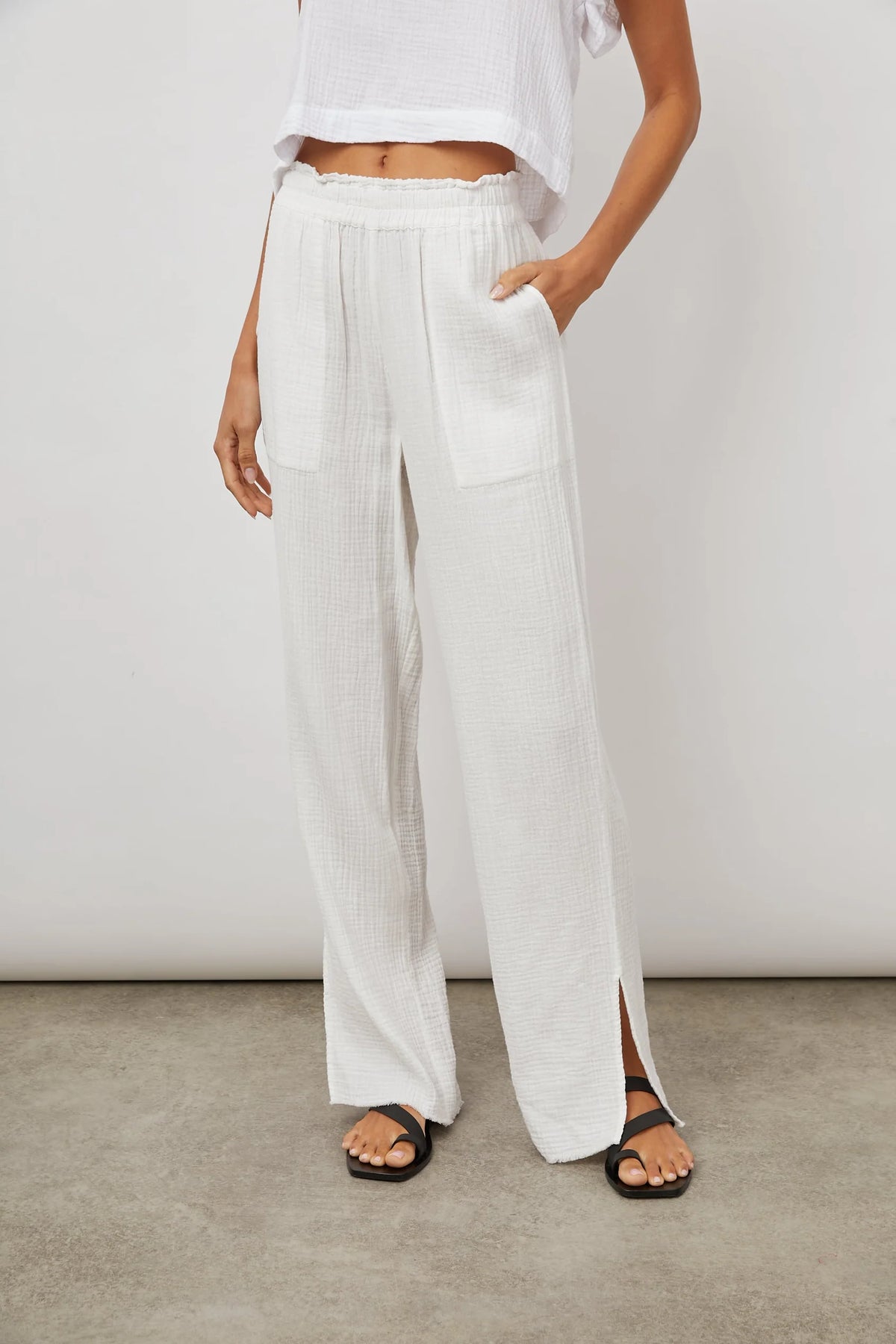 Long white cheese-cloth style wide leg trousers with side splits and elasticated waist with pockets