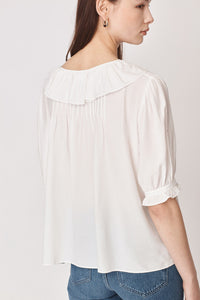 White pull on blouse with ruffle collar and tie detail elbow length sleeves with ruffle detail