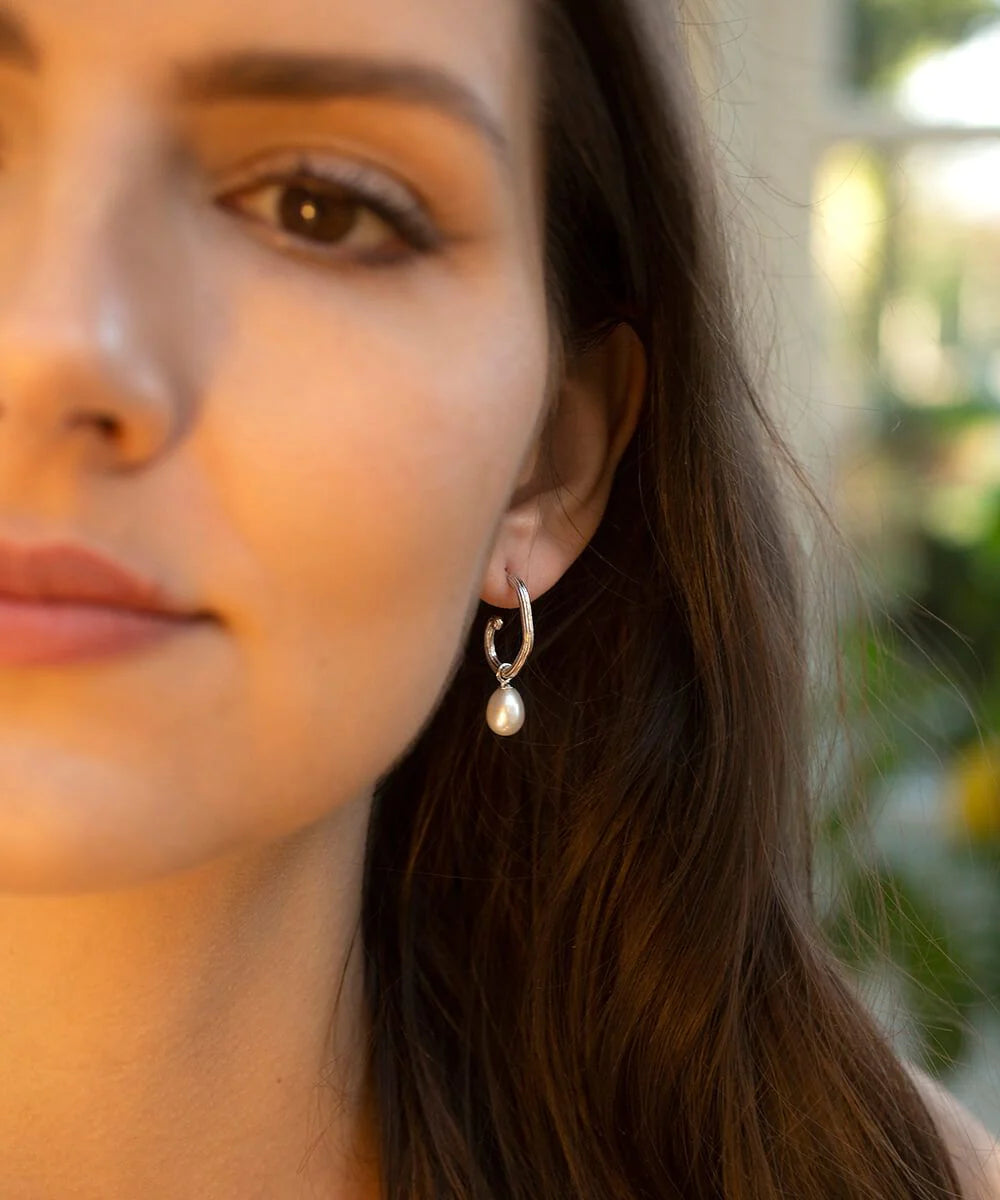 Silver grooved tubing hoop earrings with post and butterfly fastening and single pearl drop pendant