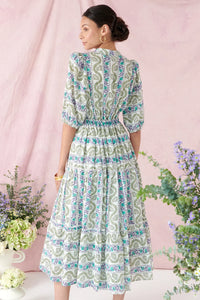 Midi dress with stand up collar half placket and gold button fastenings short sleeves and triple tiered skirt with ladder lace inserts in ecru fabric with green and purple floral print