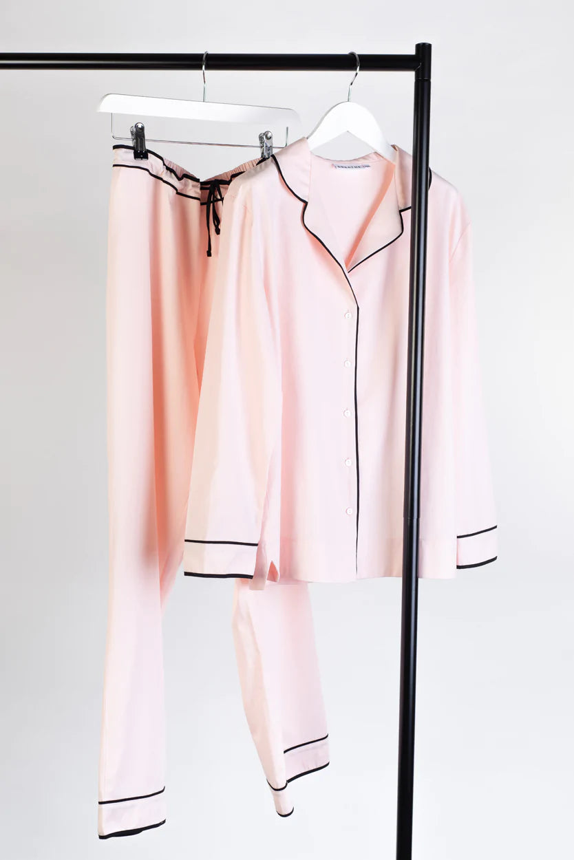 Light pink classic pyjama top and long trouser bottoms with black piping detail