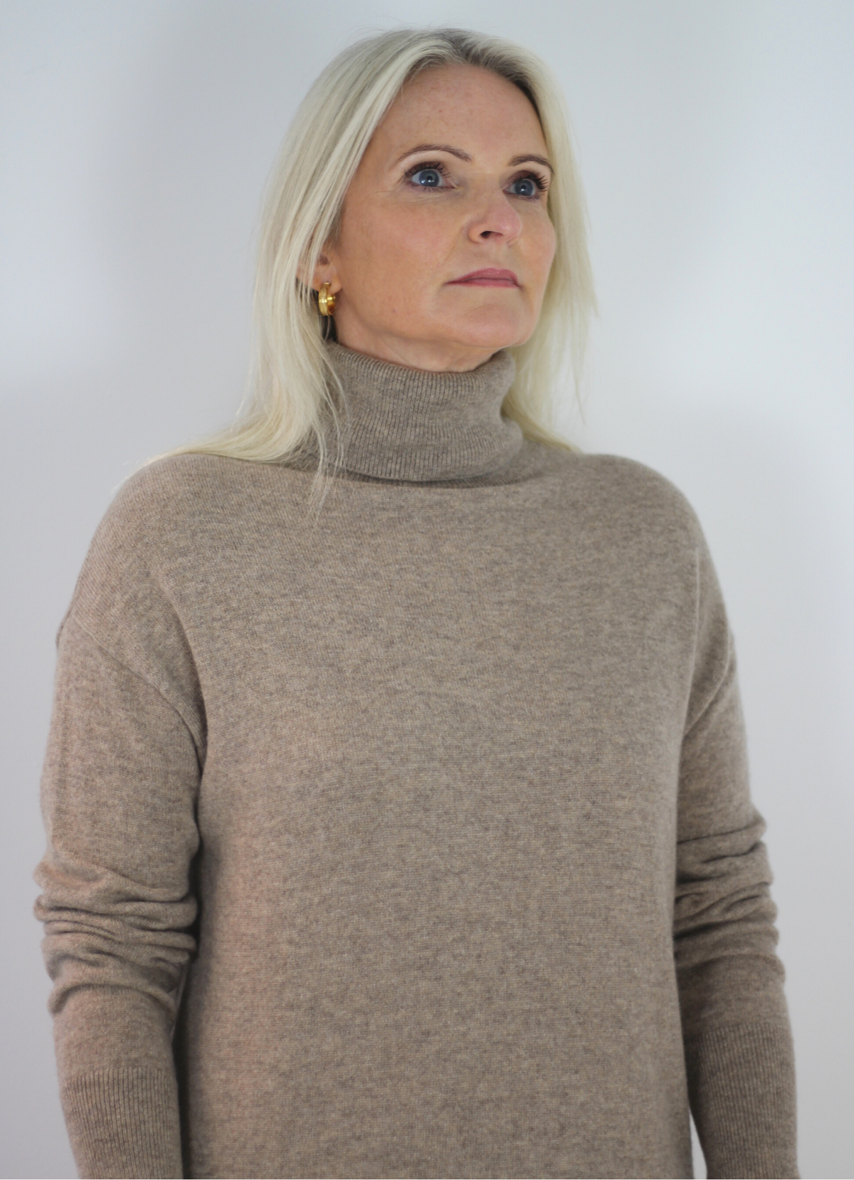 Light fawn coloured cashmere dress with roll neck, ribbed cuffs and side splits.