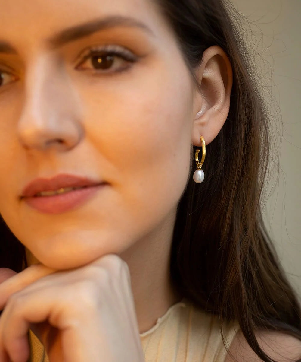 Gold plated grooved tubing hoop earrings with post and butterfly fastening and single freshwater pearl pendant