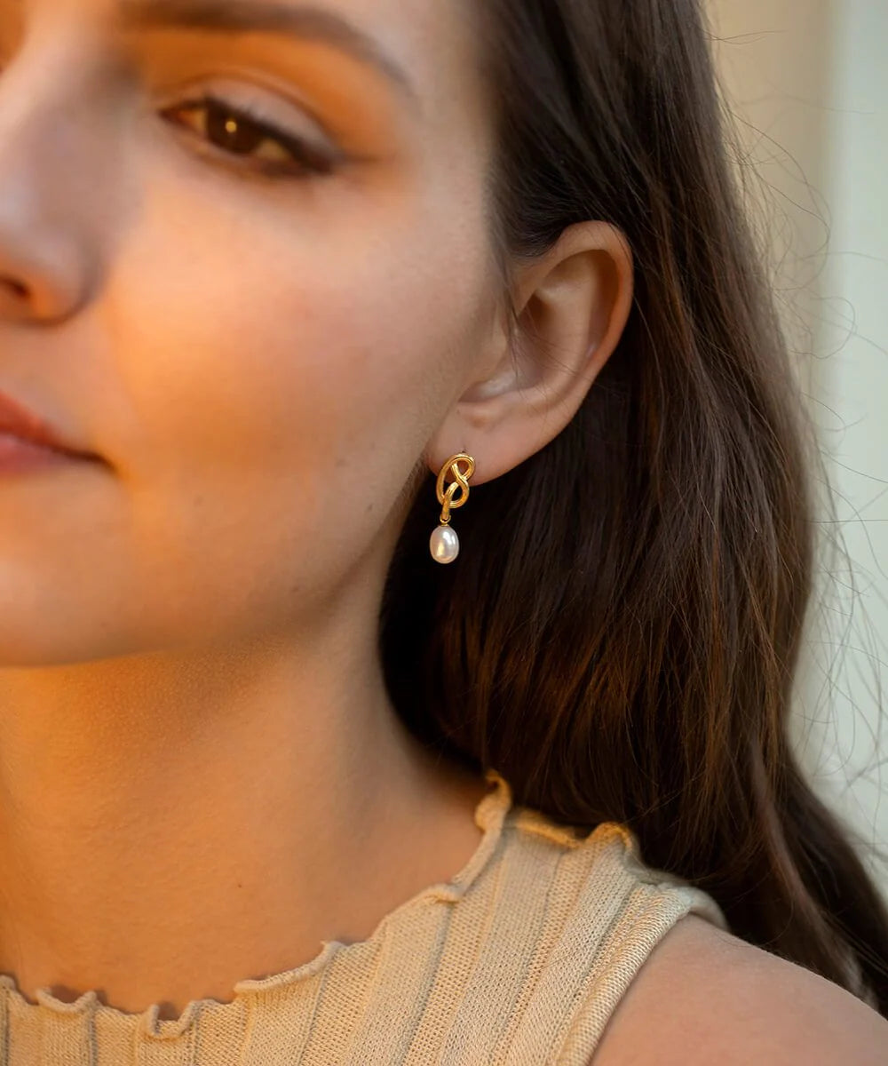 Gold twisted earring with post and butterfly fastening with single pearl drop