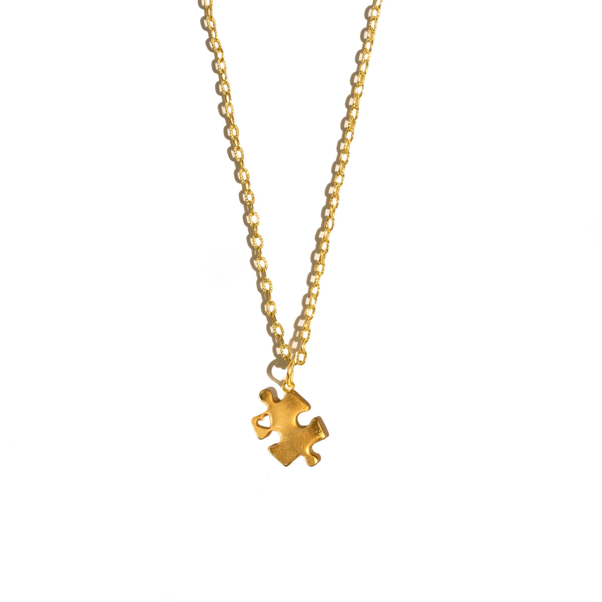 Gold necklace with a jigsaw puzzle piece charm