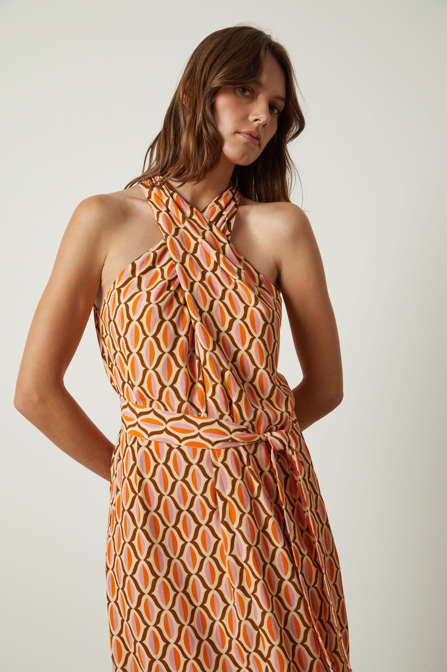 Twisted neck sleeveless midi dress with matching self tie belt in orange and pink geometric print