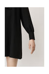 Short A line black dress with long sleeves gathered at the cuff and shoulder with a ruffle at the front crew neck zip fastening at the centre back
